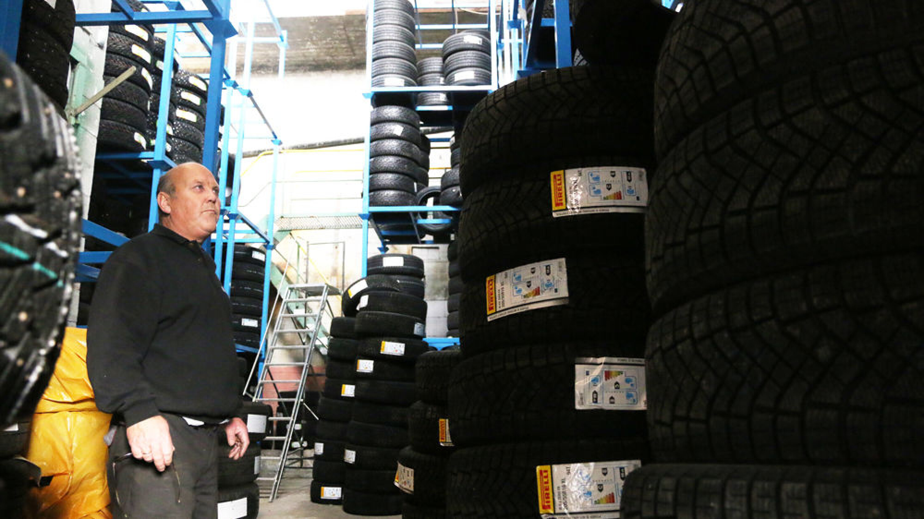 VARIERT UTVALG: Med eller uten pigg, vanlig dekk, 4x4 dekk eller 28-tommers til firhjulstrekkeren? Eiker Motorshop har et stort utvalg i butikk og på lager. På bildet er Svein Rusts bror, Eilef, som viser fram alle godbitene dekkbedriften har på lageret.