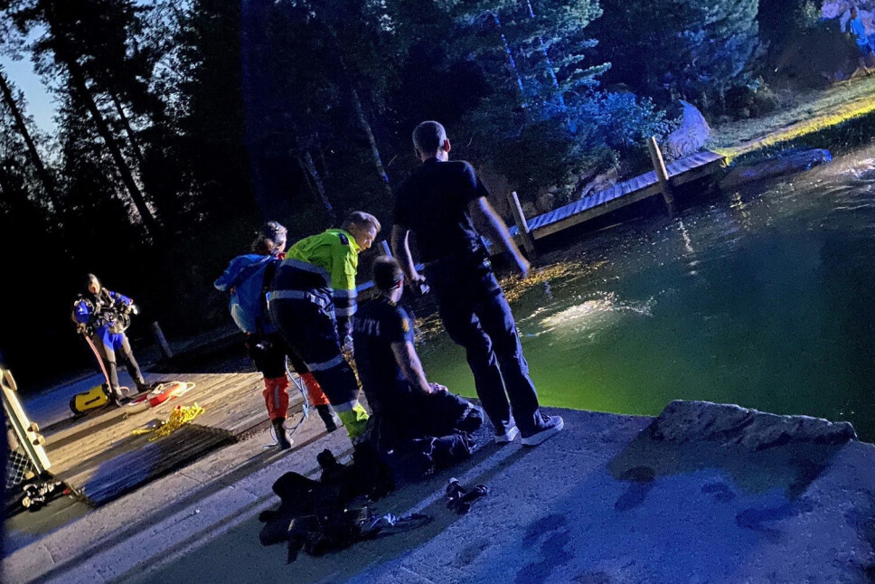 I GANG MED SØK: Her er redningsdykkere i aksjon for å finne mannen ved demningen på badeplassen.