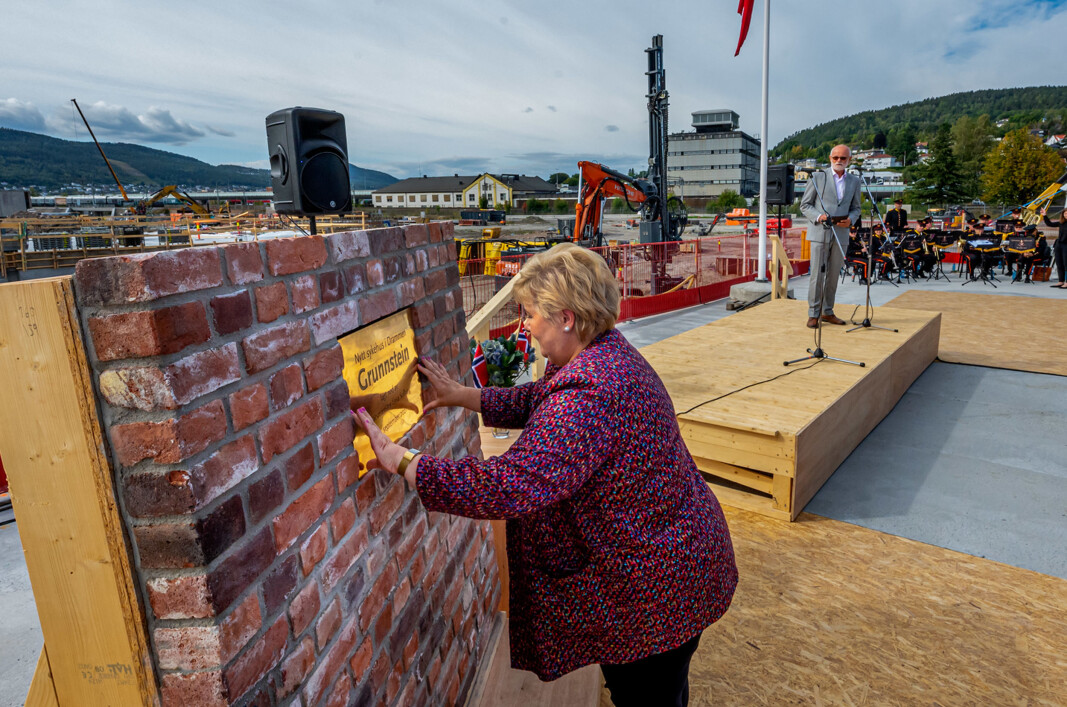 GRUNNSTEIN: Statsminister Erna Solberg plasserer grunnsteien til sykehuset i en teglsteinsmur fra det gamle industriområdet. I bakgrunnen Arnstein Hodne som har hovedansvar og daglig tilsyn med prosjektet. GRUNNSTEIN: Statsminister Erna Solberg plasserer grunnsteien til sykehuset i en teglsteinsmur fra det gamle industriområdet. I bakgrunnen Arnstein Hodne som har hovedansvar og daglig tilsyn med prosjektet.