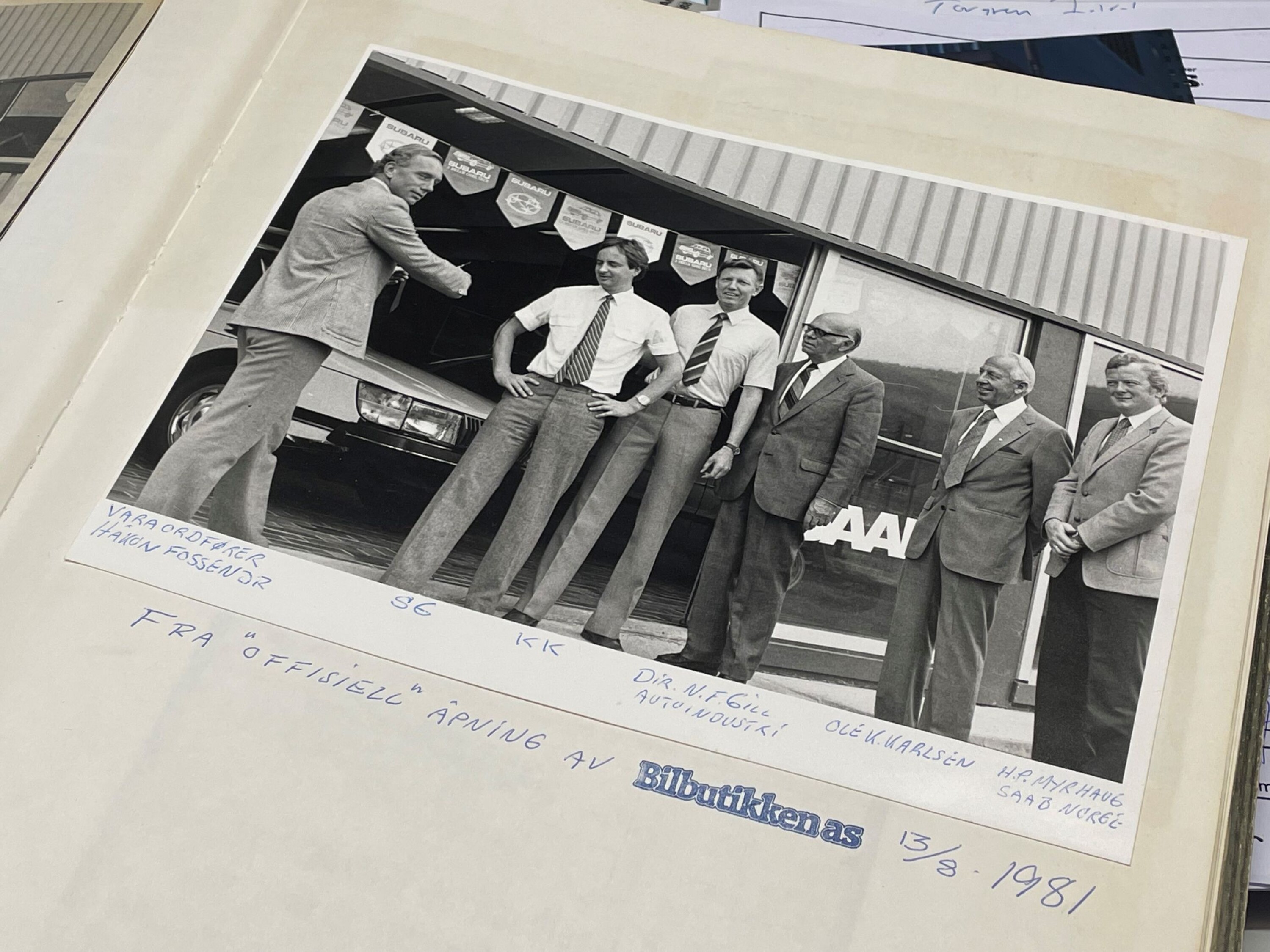 40 ÅR SIDEN: Stein Grøndal blar i en perm full av utklipp og historiske bilder på kontoret. Her fra åpningen i 1981, med daværende kompanjong Knut Kjenner, og varaordfører Håkon Fossen.