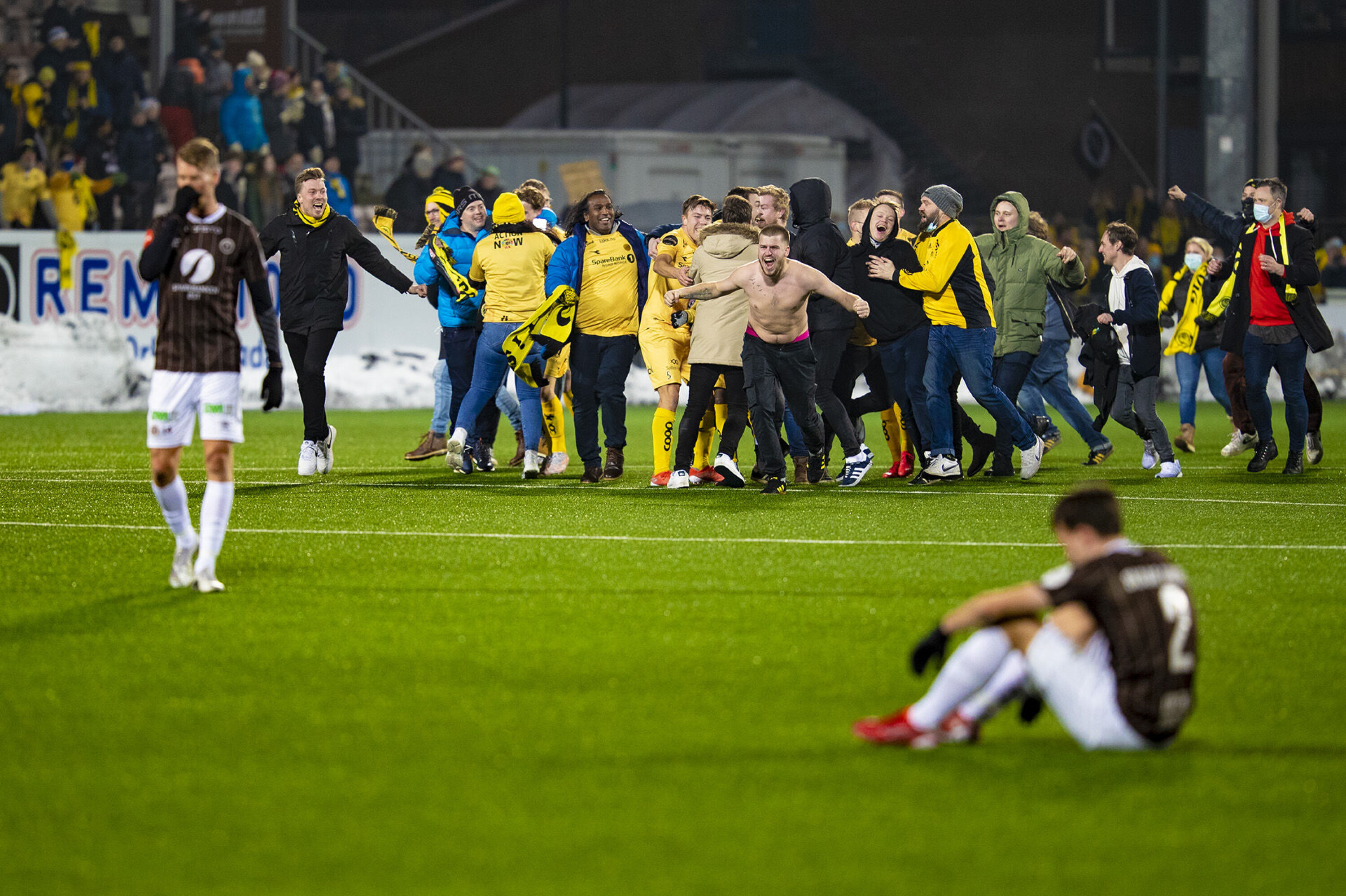 BANESTORMING: Glimt-fansen stormet banen mens Mjøndalen-spillerne fortvilte etter kampen.