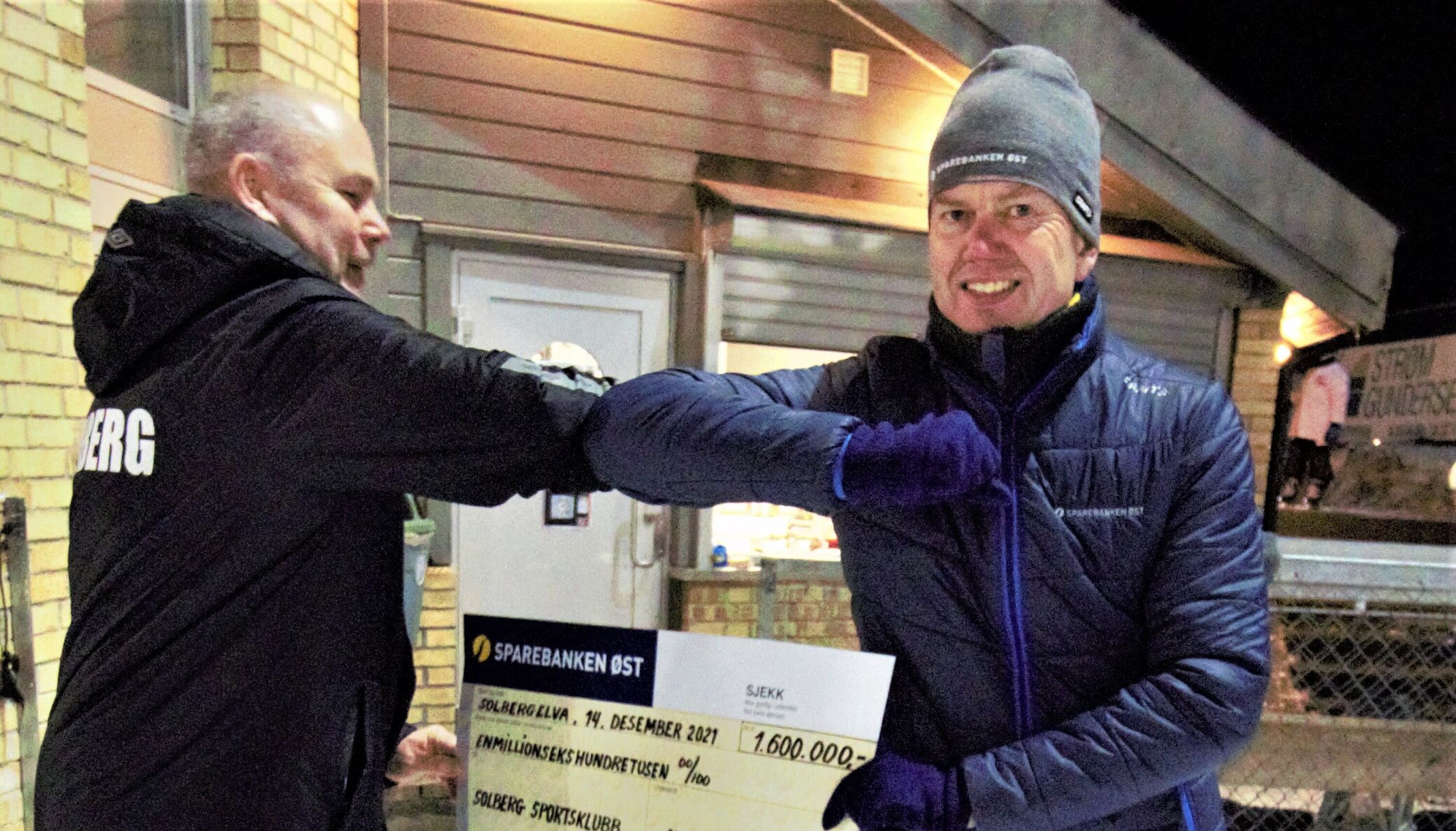 Solbergs styreleder Frode Enger kan ta i mot det synlige beviset for 1,6 millioner i støtte fra Sparebanken Øst ved Per-Øyvind Mørk.