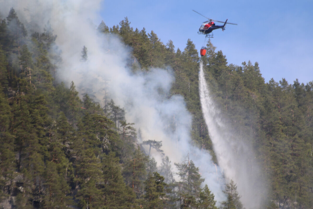 ULENDT TERRENG: Her er skogbrannhelikopteret i aksjon, mandag har bakkemannskapene fått bistand fra to helikoptre som har gjort god nytte for seg. ULENDT TERRENG: Her er skogbrannhelikopteret i aksjon, mandag har bakkemannskapene fått bistand fra to helikoptre som har gjort god nytte for seg.