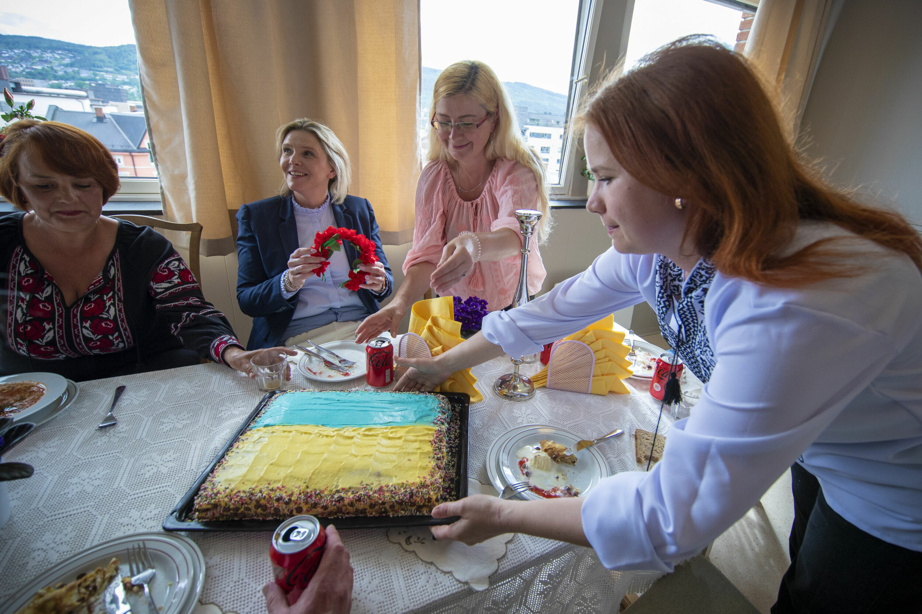 KAKE OG HÅRPRYD: De ukrainske kvinnene hadde stått på for å gi Listhaug en like varm mottagelse som de selv hadde fått, og bød på kake i det ukrainske flaggets farger - og en tradisjonell ukrainsk hårbøyle fikk Frp-lederen også med seg.