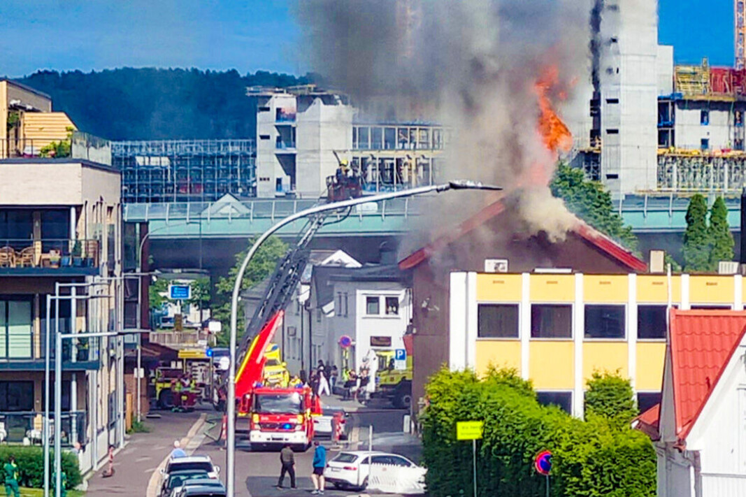 SPERRET AV GATA: Det brenner i en eldre trebygning. Flammene slo opp av taket. SPERRET AV GATA: Det brenner i en eldre trebygning. Flammene slo opp av taket.