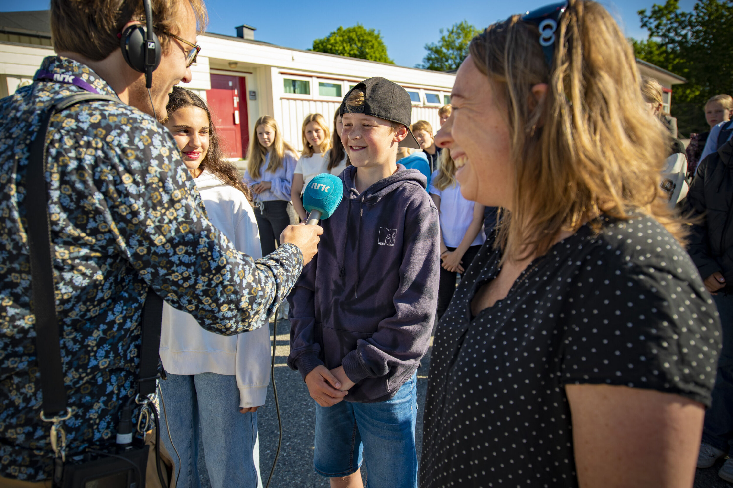I RAMPELYSET: Lilly Sjahbazi (t.v.) og Sander Akselsen (i midten) fra i skolekoret på Vestbygda intervjues her av NRK-reporter Hans Kristian Rangnes. Til høyre musikklærer Linn Kristin Hunstad.