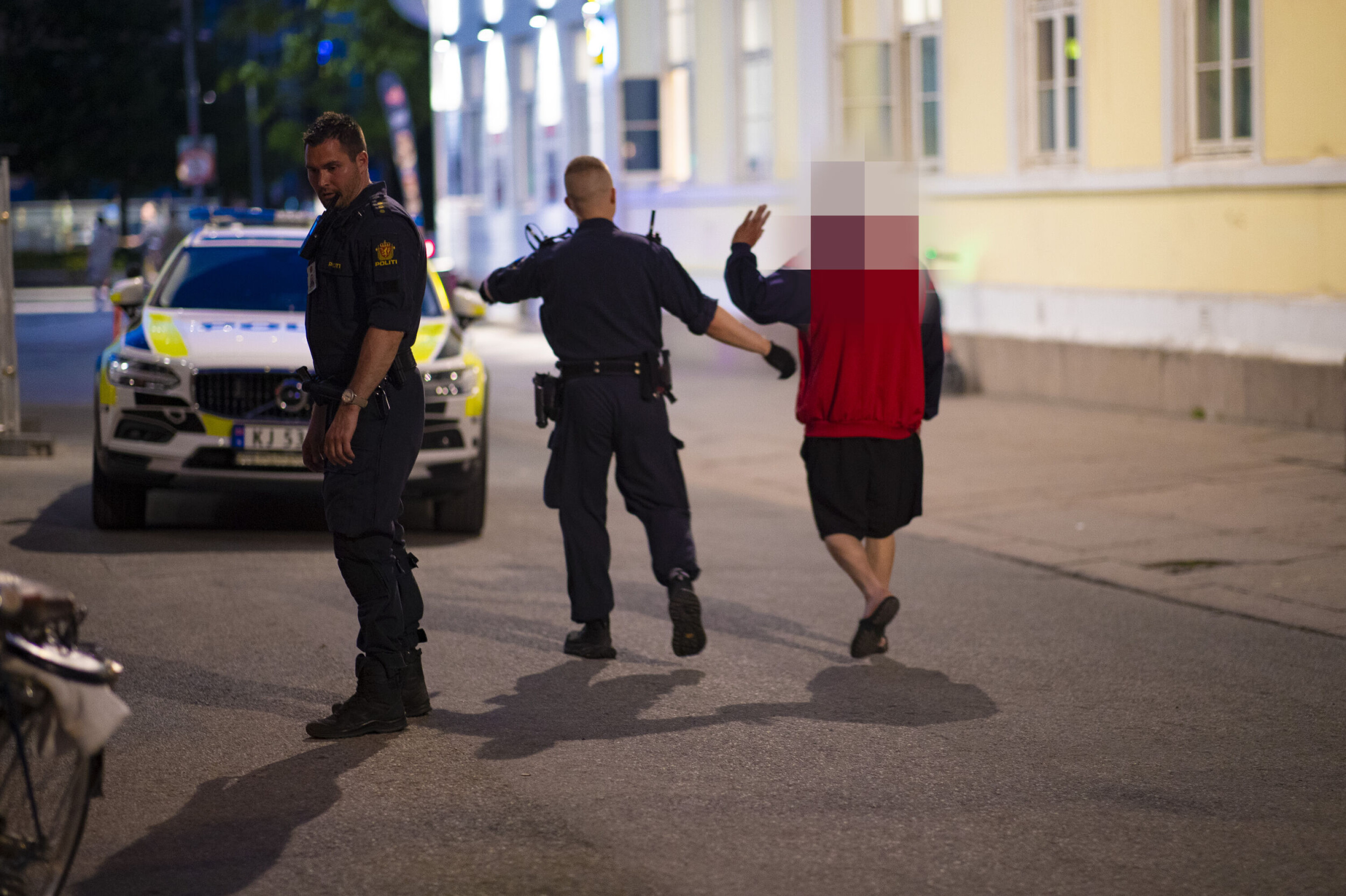 INNBRAGT: Her blir mannen fraktet arresten av politiet, som ser på gjenstandene som ble kastet ned på Tollbugata.