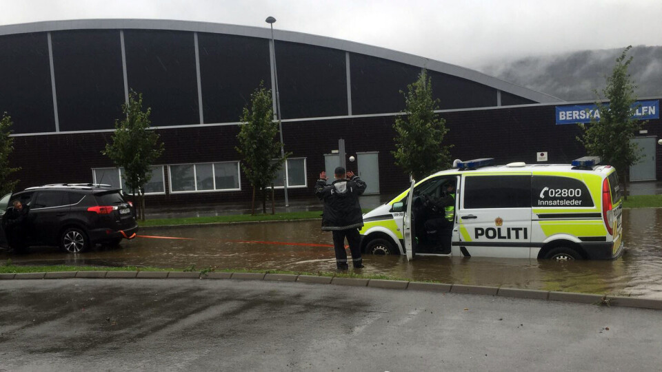 BOM FAST: Politiets innsatsleder-bil ble stående fast i vannmassene utenfor Berskaughallen og måtte taues av tilfeldig forbipasserende. FOTO: EIRIK STEGARUD / DRM24.NO