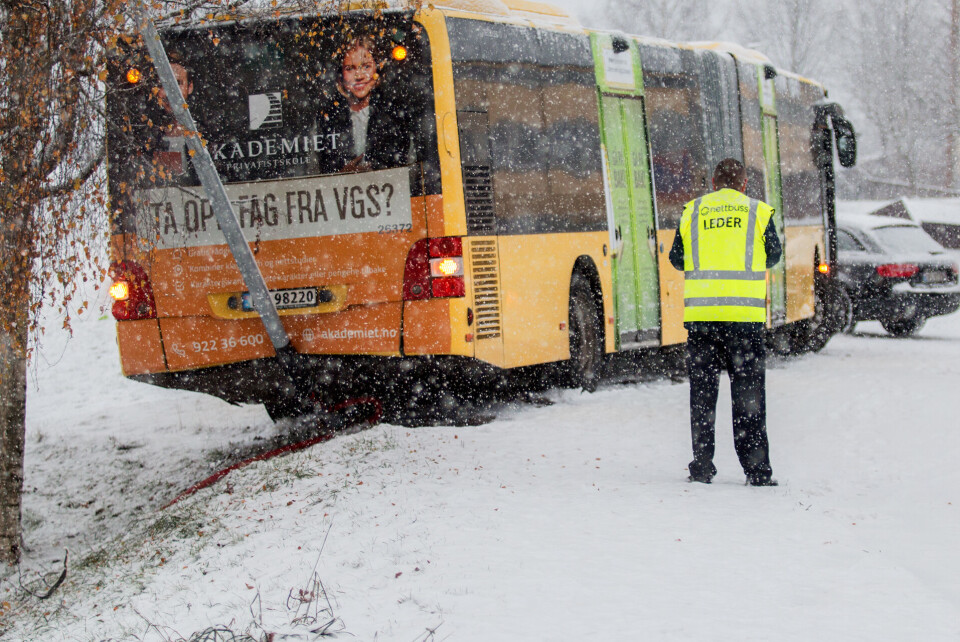 KUNNE GÅTT ILLE: Denne leddbussen på Fjell var full av passasjerer da den uten kjetting seilte bakover. Hadde det ikke vært for lyktestolpen som igjen hvilte mot et tre, hadde den fortsatt ned en bratt skråning og inn i en garasjerekke.