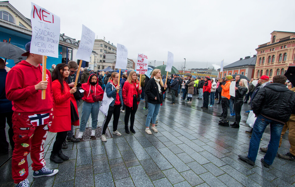 STILLE PROTEST: Det var ingen organisert protestaksjon på Frps 1. mai-arrangement slik man har sett tidligere, men disse rødkledde ungdommene med plakater vendte Frp-talerne ryggen. (FOTO: ALEXANDER JANSEN / DRM24)