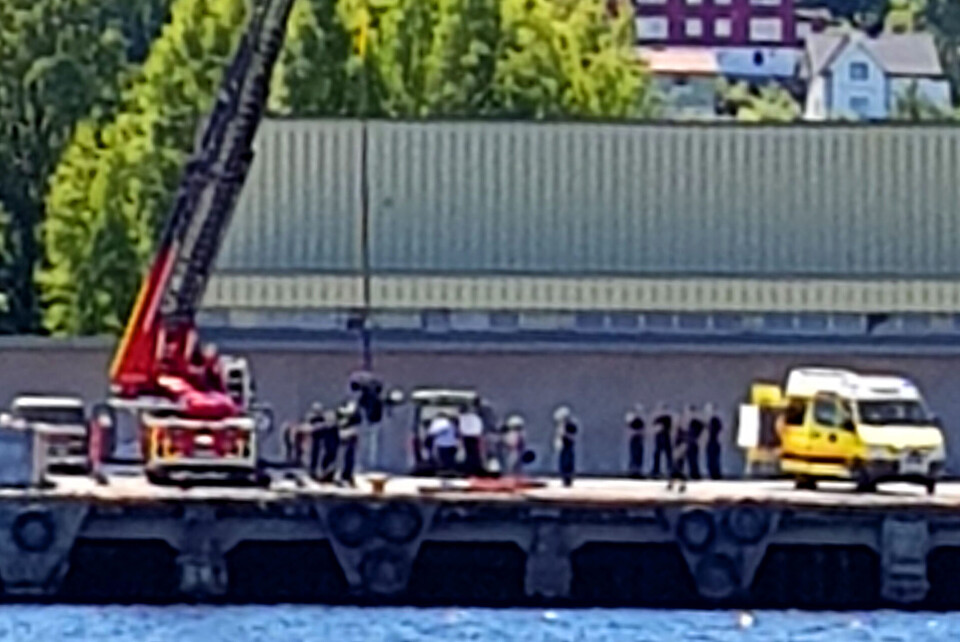 HEIST OPP AV VANNET: Her blir det som formentlig er kvinnens elektriske rullestol heist opp av vannet - rett utenfor brygga på Tangenkaia i Drammen. (FOTO: LESERBILDE)