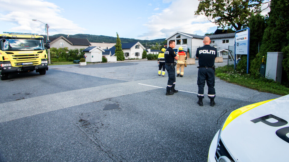 SPERRET: Politiet har sperret Strandveien i Mjøndalen mens brannvesenet forsøker å sikre taket som har blåst over bygningen i bakgrunnen. (FOTO: ALEXANDER JANSEN / DRM24)