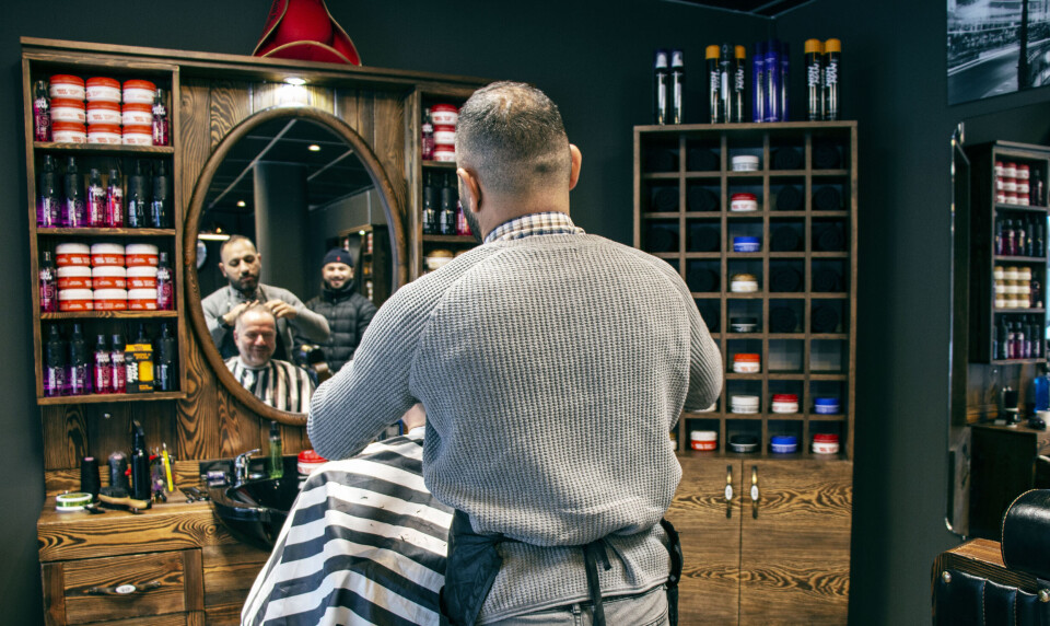 ELDRE AMERIKANSK STIL: Interiøret er inspirert fra den gammeldagse amerikanske stilen barbershopene hadde på 60-tallet. - Jeg hadde lyst til å skape noe annerledes, forteller Ari. Her sammen med fetteren og en ny kunde.