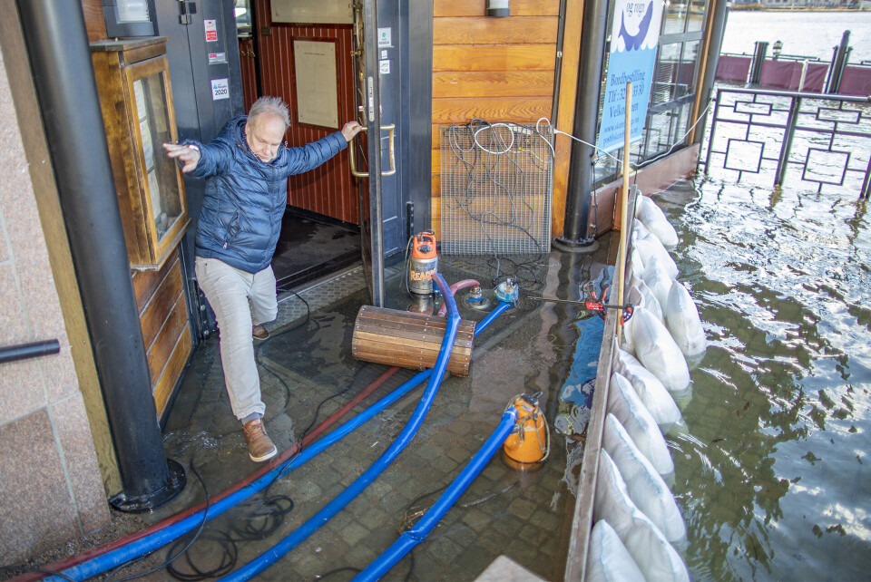 ALLE MANN TIL PUMPENE: Bjørn Herstad er en av flere som jobbet febrilsk for å holde vannet ute av restauranten, men her var det allerede vått på gulvet innenfor dørstokken.