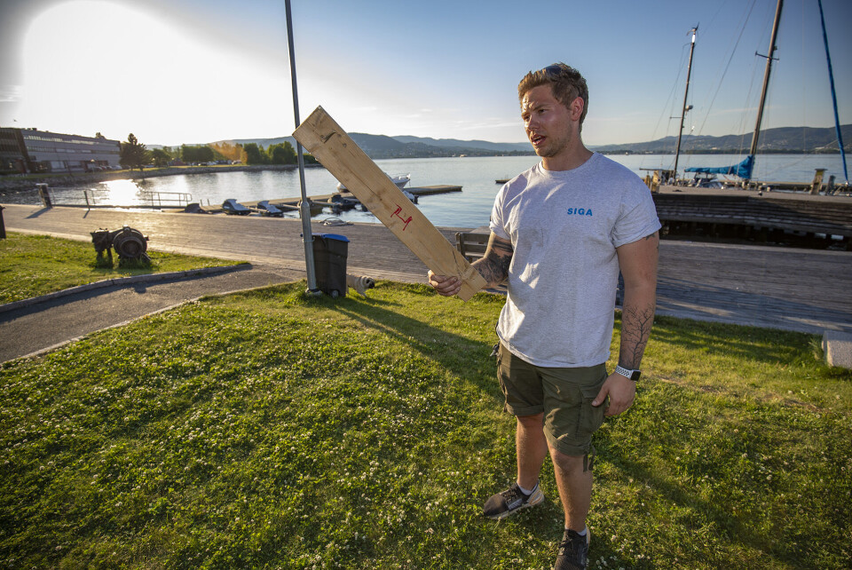 VITNE: Joakim Odden viser frem den tunge planken med spiker som guttene brukte å slå med. (FOTO: ALEXANDER JANSEN / DRM24)