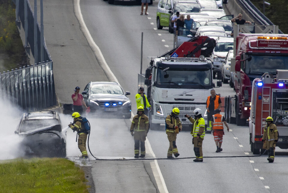 BRANN: Bilen ble helt utbrent. Her jobber brannvesenet med slukking.