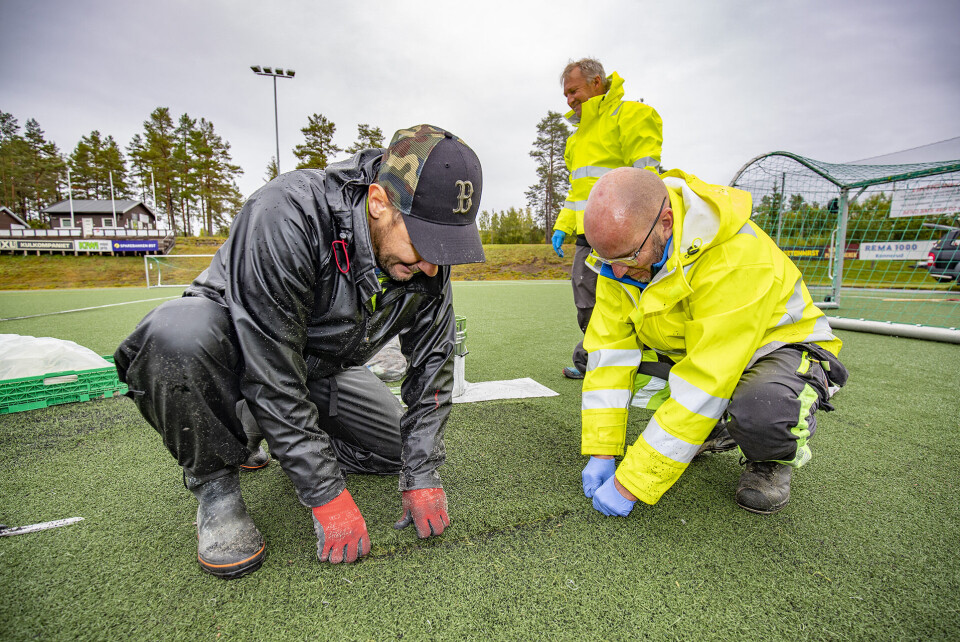 FIKSET: Tor Gundersen, (t.h.), Mats Eriksson, og Kai Ove Balterud (bak) i ferd med å legge siste hånd på verket etter reparering av kunstgressmatta.