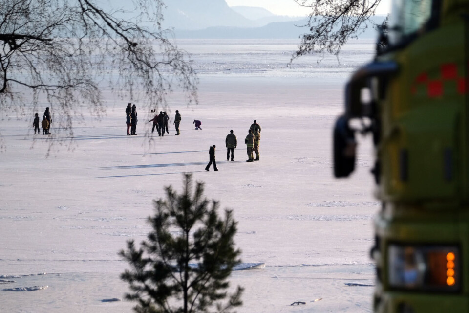 LEK MED LIVET: Grunnet strømninger i vannet kan det være svært ulik isdybde på fjorden. Her er brannvesenet på plass for å kontrollere.