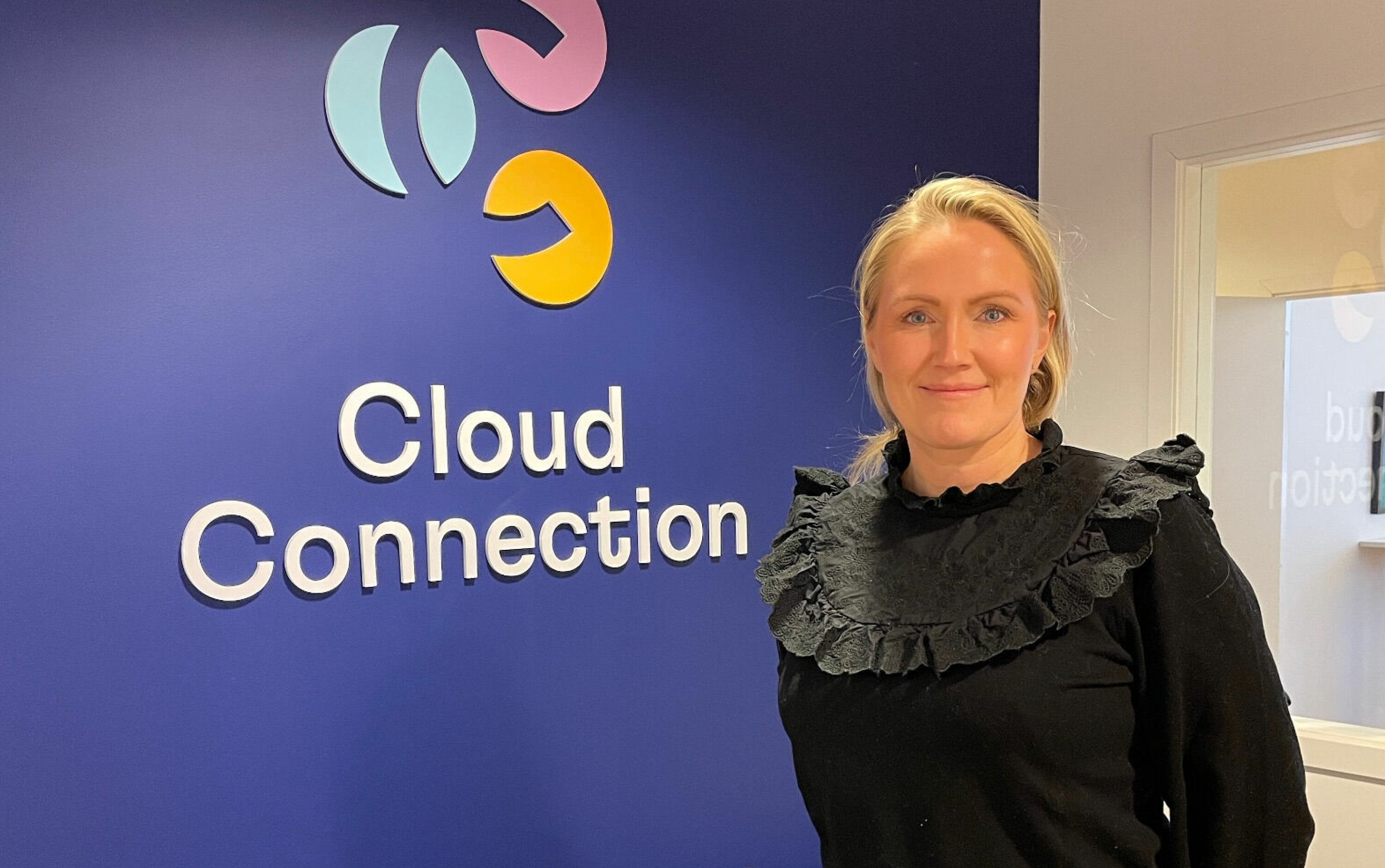 Kristine Dalen, ny direktør for CRM i Cloud Connection foran selskapets nye logo.