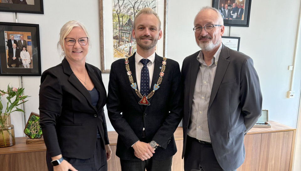 Ordfører Adrian Tollefsen med nyrestaurert kjede sammen med gullsmed Rita Dammen og banksjef Pål Strand.