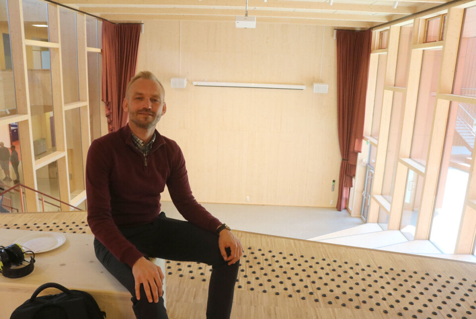 Ordfører Adrian Tollefsen var godt fornøyd med det han hørte om økonomi og byggeperiode under dagens signering. Her sitter han i det store atriumet i hovedbygget på skolen.